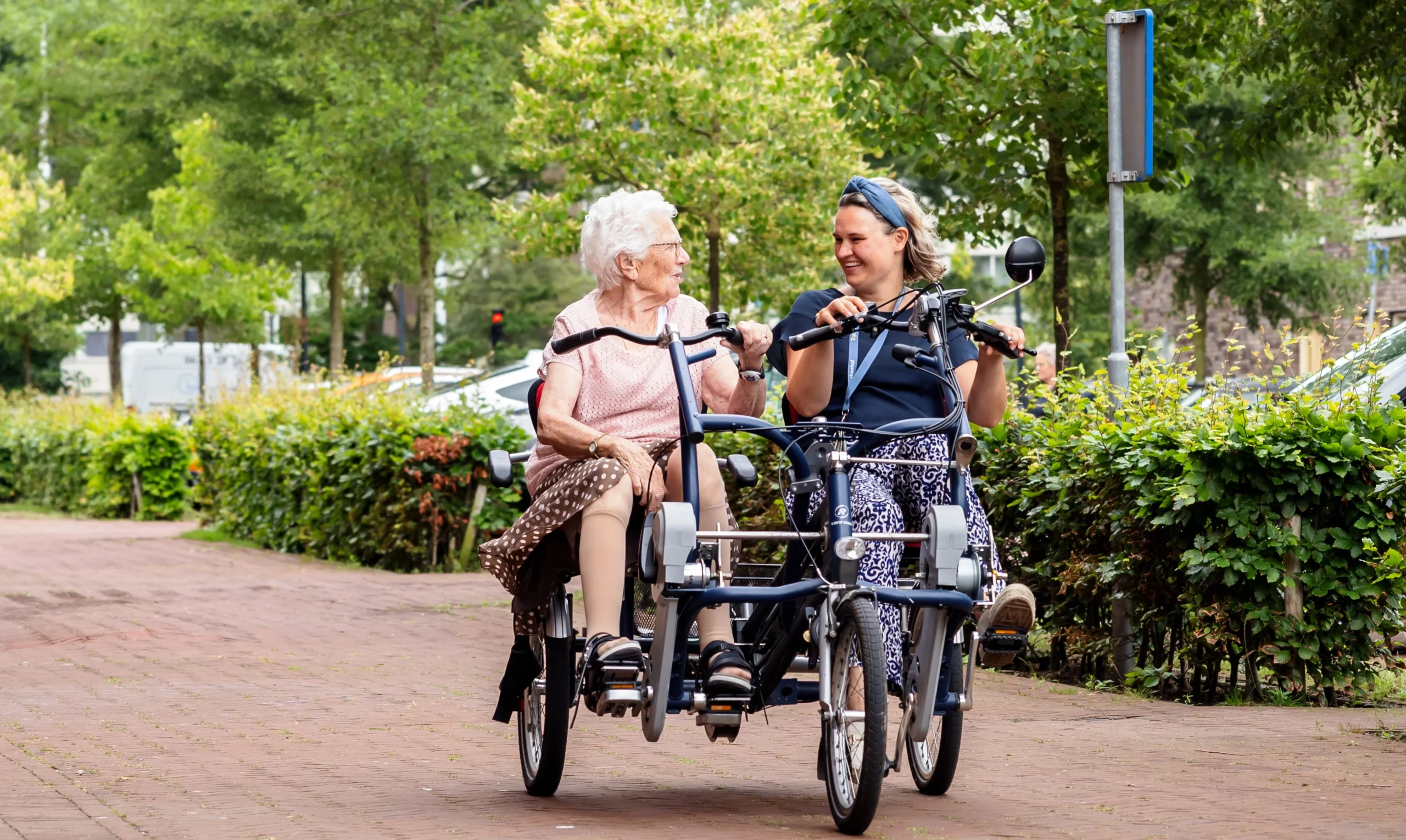 Vrijwilliger van Topaz samen met een bewoner op de fiets Vrijwilliger van Topaz samen met een bewoner op de fiets