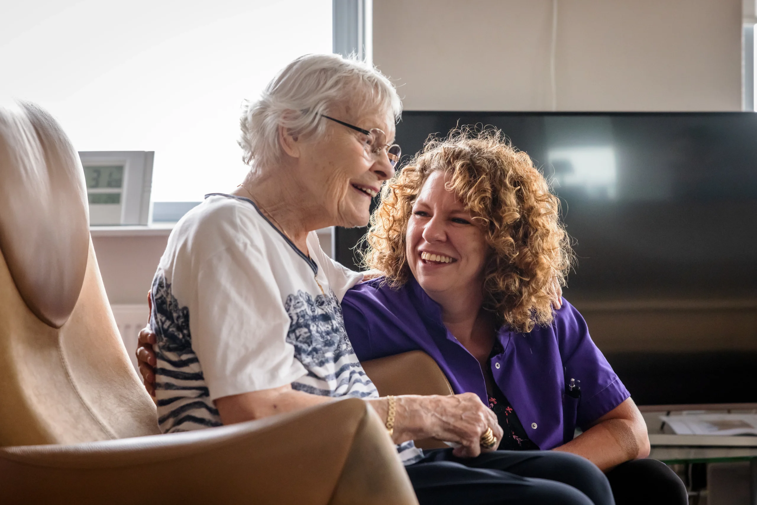 Zorgcollega van Topaz samen met een bewoner
